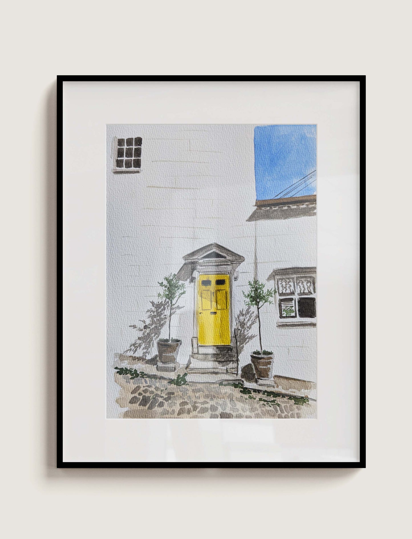 Framed watercolour painting of a yellow front door on a white townhouse in Arundel, by Daniela Militaru